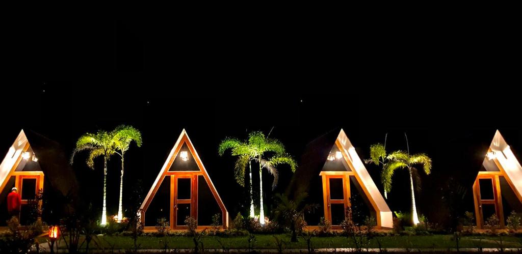 a group of buildings with palm trees at night at Hardin De Marbella in El Nido