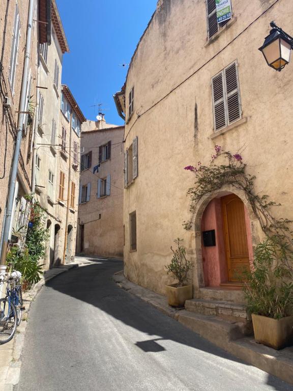 Une allée avec un bâtiment doté d'une porte rouge dans l'établissement Superbe appartement neuf et cosy en centre ville, à Hyères