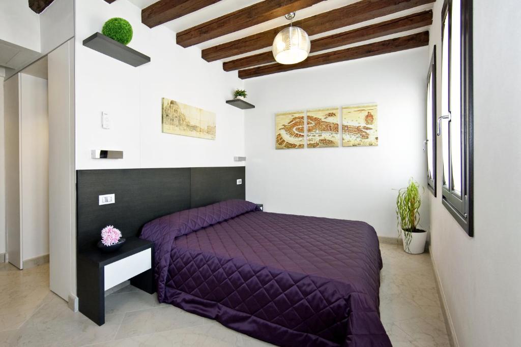 a bedroom with a purple bed in a white room at Margherita House Venice in Venice