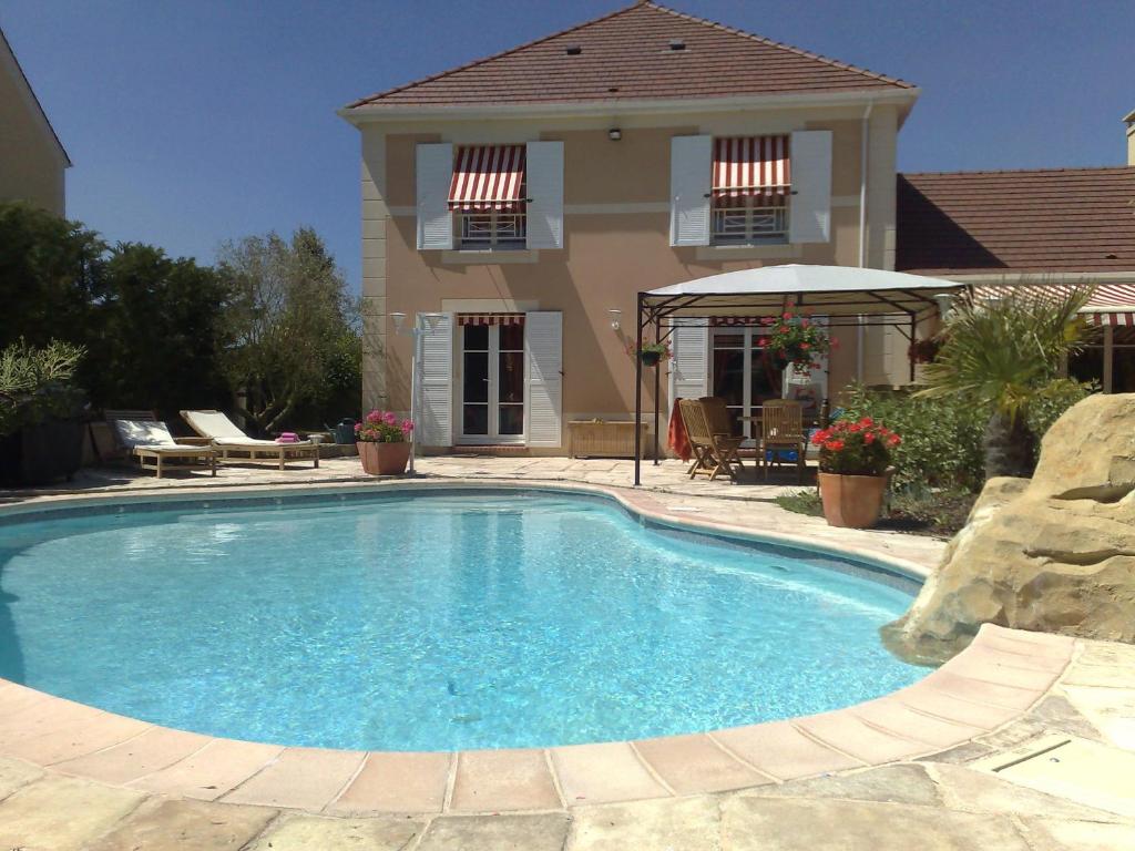 una gran piscina frente a una casa en Villa Cendrillon, en Magny-le-Hongre