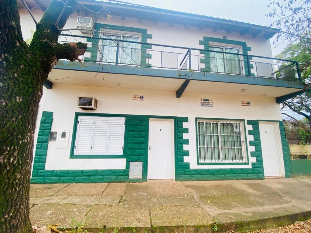 uma casa branca e verde com uma varanda em MI RIO em Colón