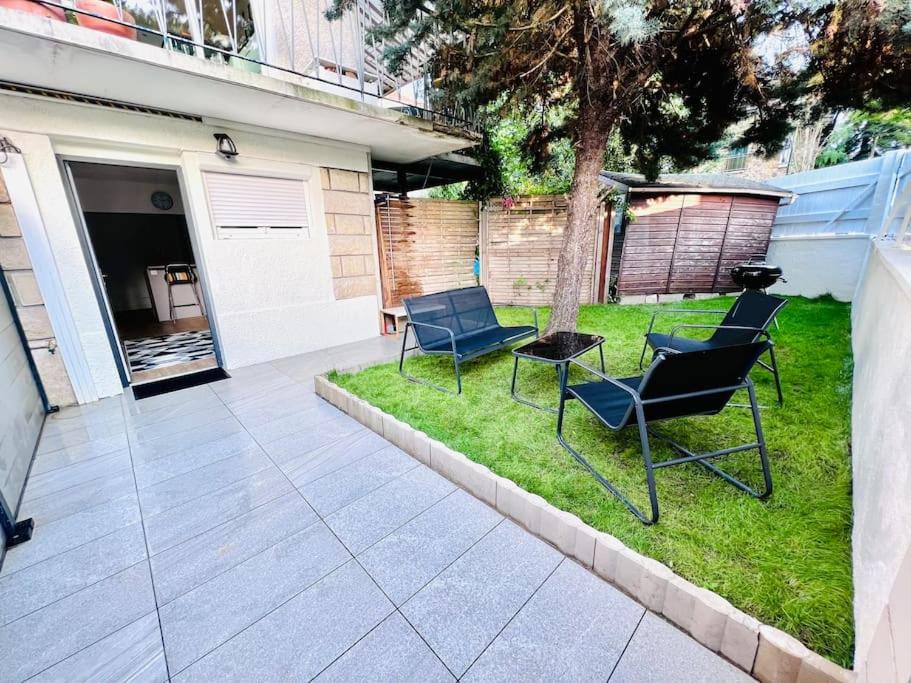 patio con 2 sedie e tavolo sull'erba di Superbe studio avec entrée et jardin privés à moins de 15 minutes de Paris a Bagneux