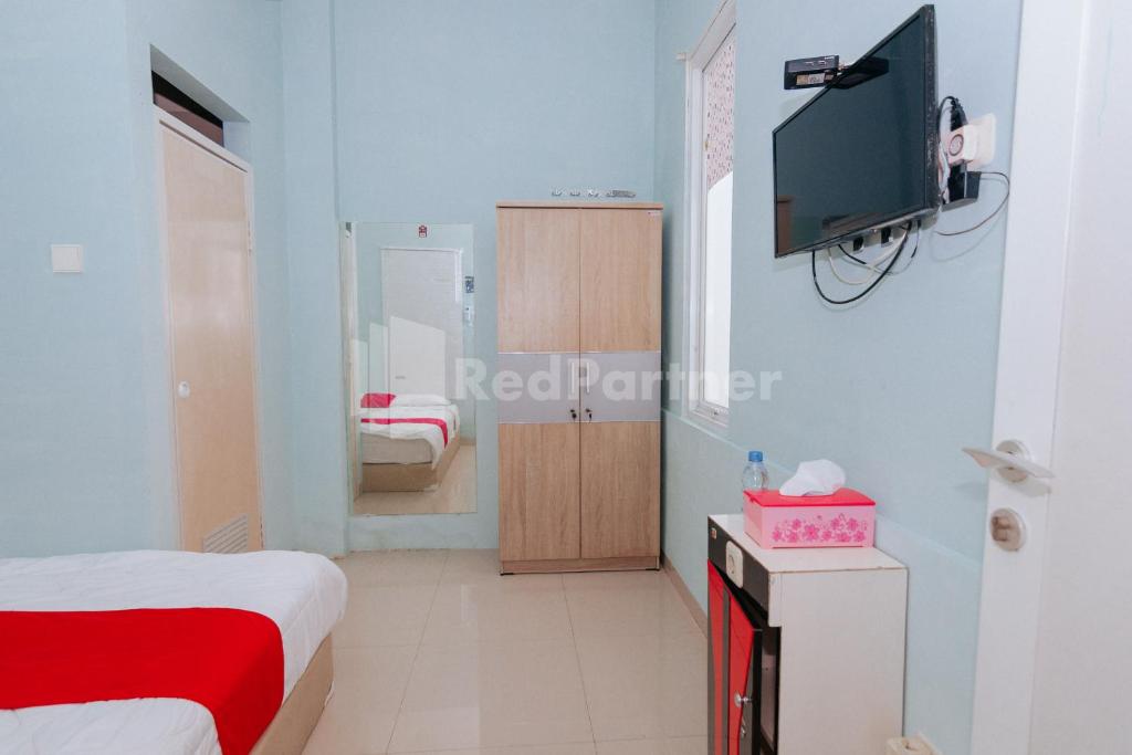 Postel nebo postele na pokoji v ubytování OYO 94494 Krekot Residence Pasar Baru COO Property