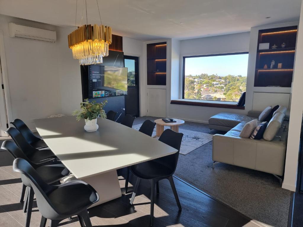 - un salon avec une table et des chaises blanches dans l'établissement RESIDENTIAL 4 BEDROOM House, à Coffs Harbour