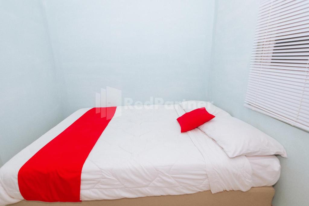 Postel nebo postele na pokoji v ubytování OYO 94494 Krekot Residence Pasar Baru COO Property