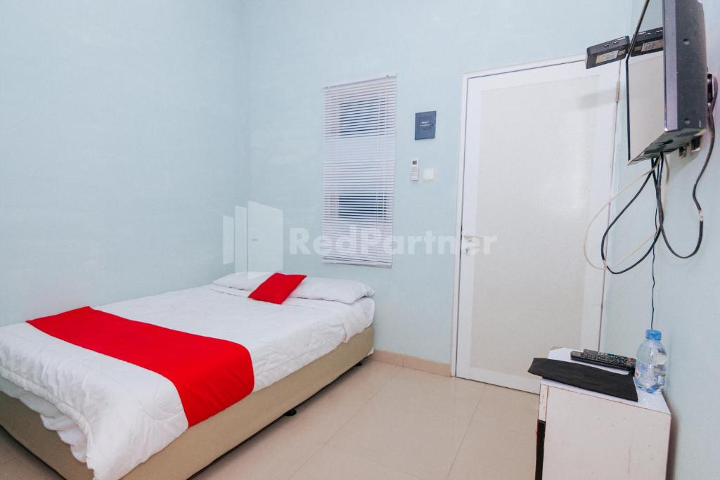 Postel nebo postele na pokoji v ubytování OYO 94494 Krekot Residence Pasar Baru COO Property