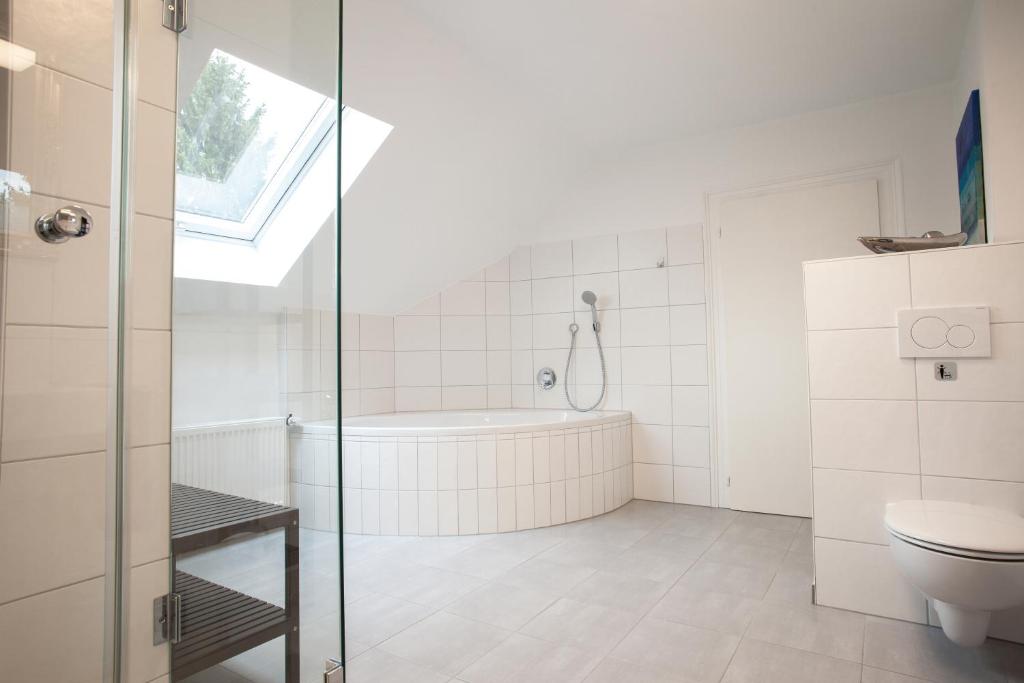 ein Badezimmer mit einem WC und einer Badewanne in der Unterkunft P&G Rooms in Höhr-Grenzhausen