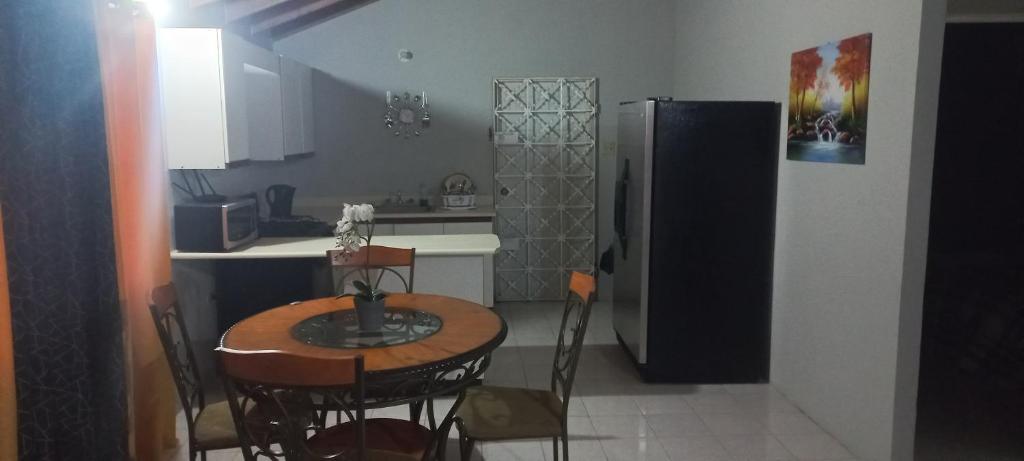 uma cozinha com uma pequena mesa e um frigorífico em Oak Villa Montego Bay 2 em Montego Bay