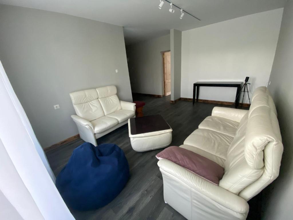 ein Wohnzimmer mit zwei weißen Stühlen und einem Sofa in der Unterkunft AVapartment in Lipuški