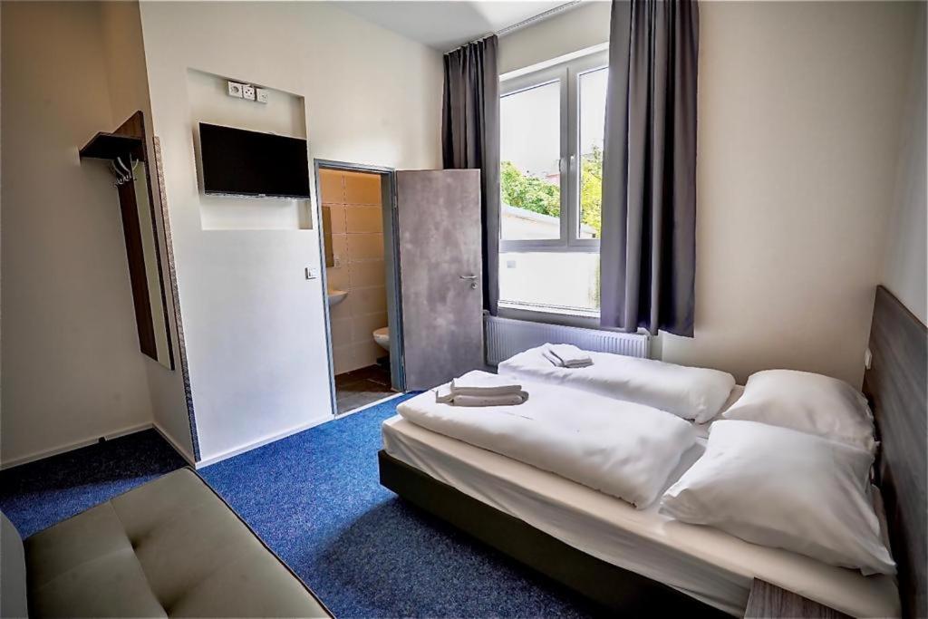 Hotel City Meetpoint في هامبورغ: غرفه فندقيه بسرير ونافذه