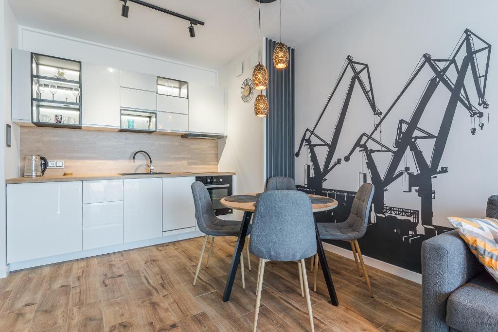 a kitchen and dining room with a table and chairs at Apartament Port in Gdynia