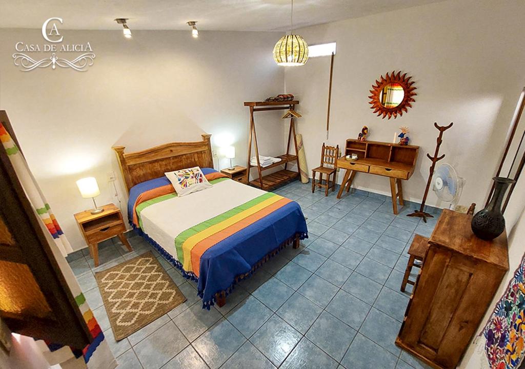 a bedroom with a bed and a desk in it at Casa de Alicia Habitación Monte Albán in Oaxaca City