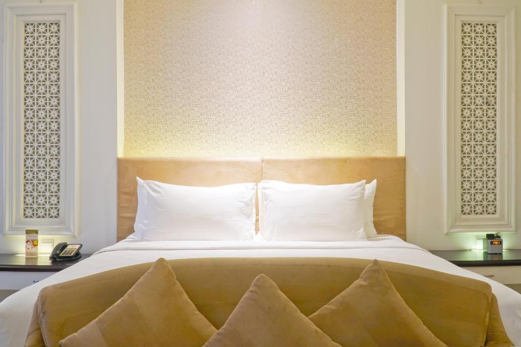 Postel nebo postele na pokoji v ubytování Swiss-Belhotel Lampung