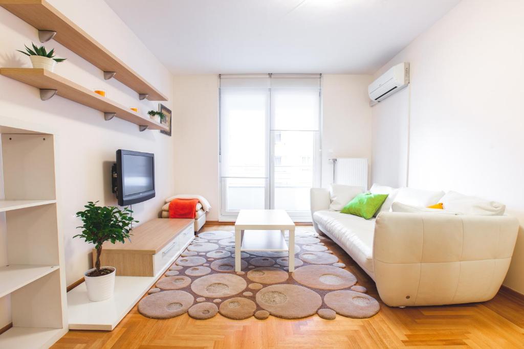 sala de estar con sofá blanco y TV en Apartment Lana, en Zagreb