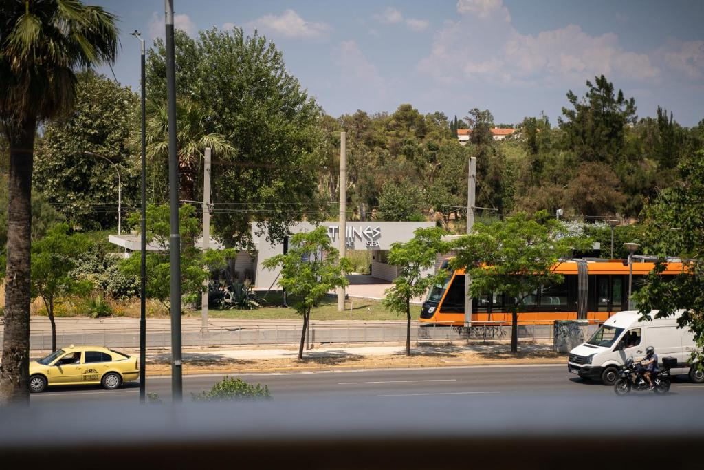 a city street with cars and a yellow taxi at Parthenis Riviera Hotel in Athens