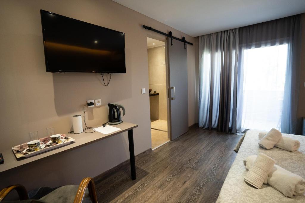 a hotel room with a television on the wall at Parthenis Riviera Hotel in Athens