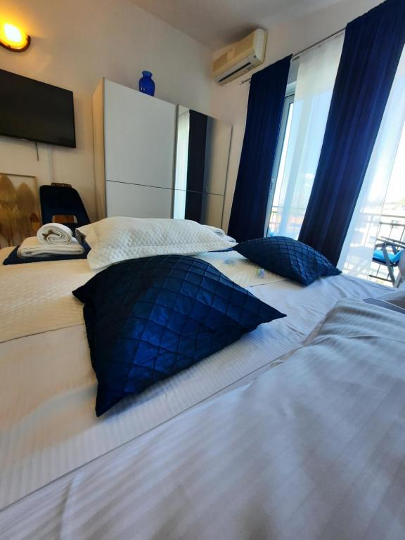 1 dormitorio con 2 camas con almohadas azules en Sweet blue en Baška Voda