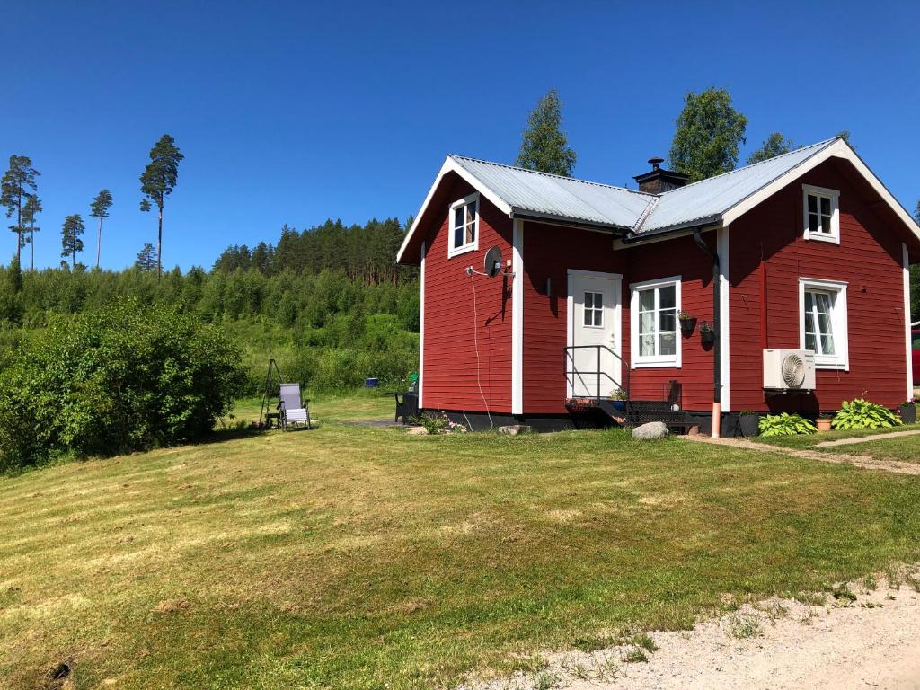 a red house on top of a grass field at Trevlig stuga nära Hovfjället in Torsby