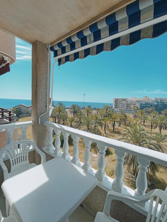 einen Balkon mit weißen Stühlen und Strandblick in der Unterkunft Apartment in Torrevieja by the Beach in Torrevieja