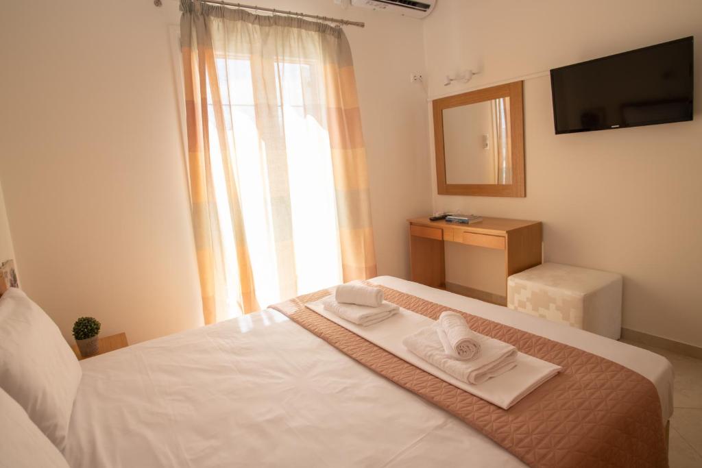 1 dormitorio con 1 cama con 2 toallas en Naxian Place, en Agios Prokopios