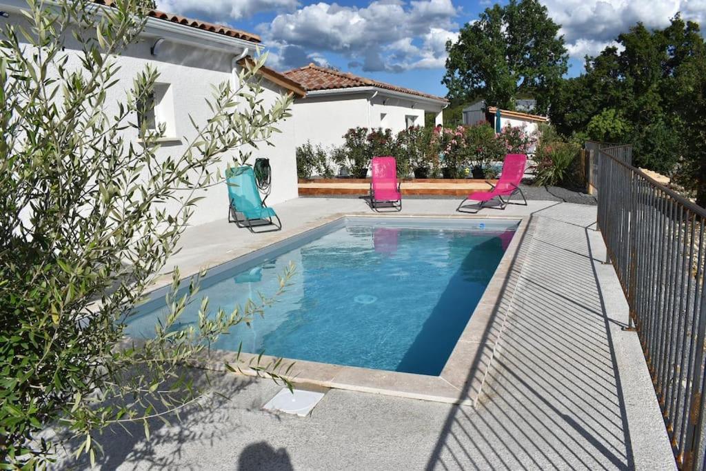 a swimming pool with three chairs and a house at Gîtes des Clapas Lisa, villa**** piscine privée in Balazuc