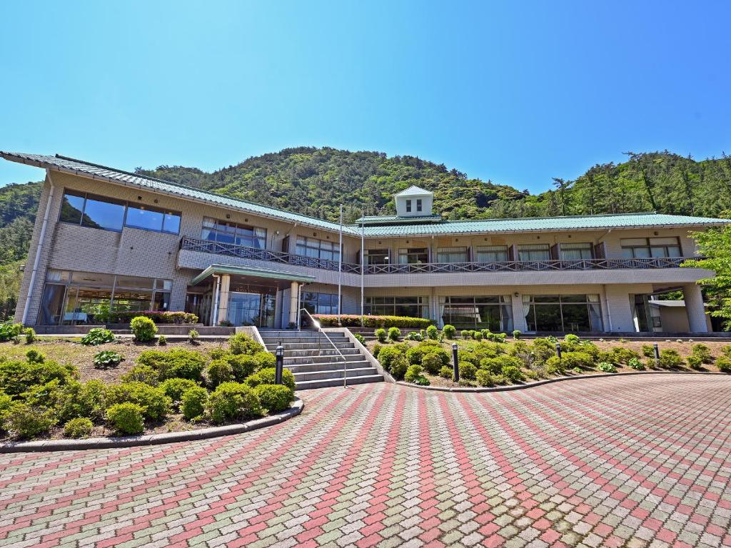 un bâtiment avec un passage en brique rouge devant lui dans l'établissement Hotel Uneri, à Okinoshima