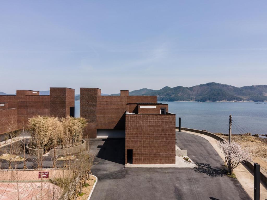 ein Backsteingebäude mit Blick auf das Wasser in der Unterkunft IJE Namhae in Namhae