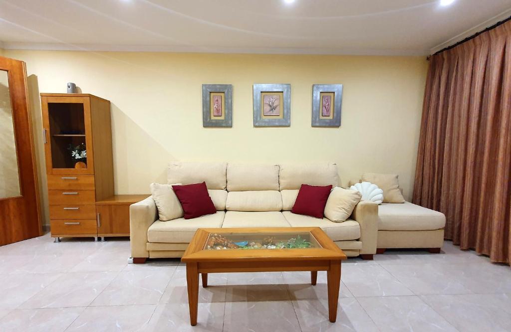 a living room with a couch and a coffee table at Piso familiar con amplia terraza 300m de la playa in Cullera