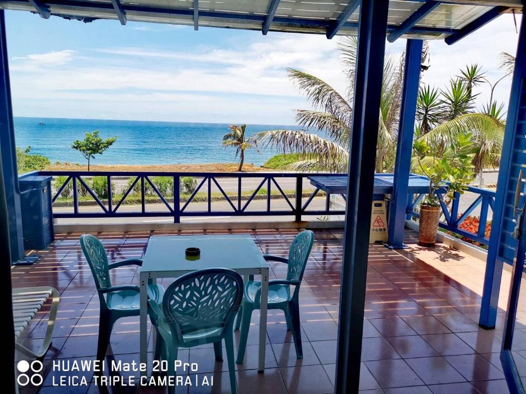 a patio with a table and chairs and the ocean at Shengtuolini B&amp;B in Yanliau