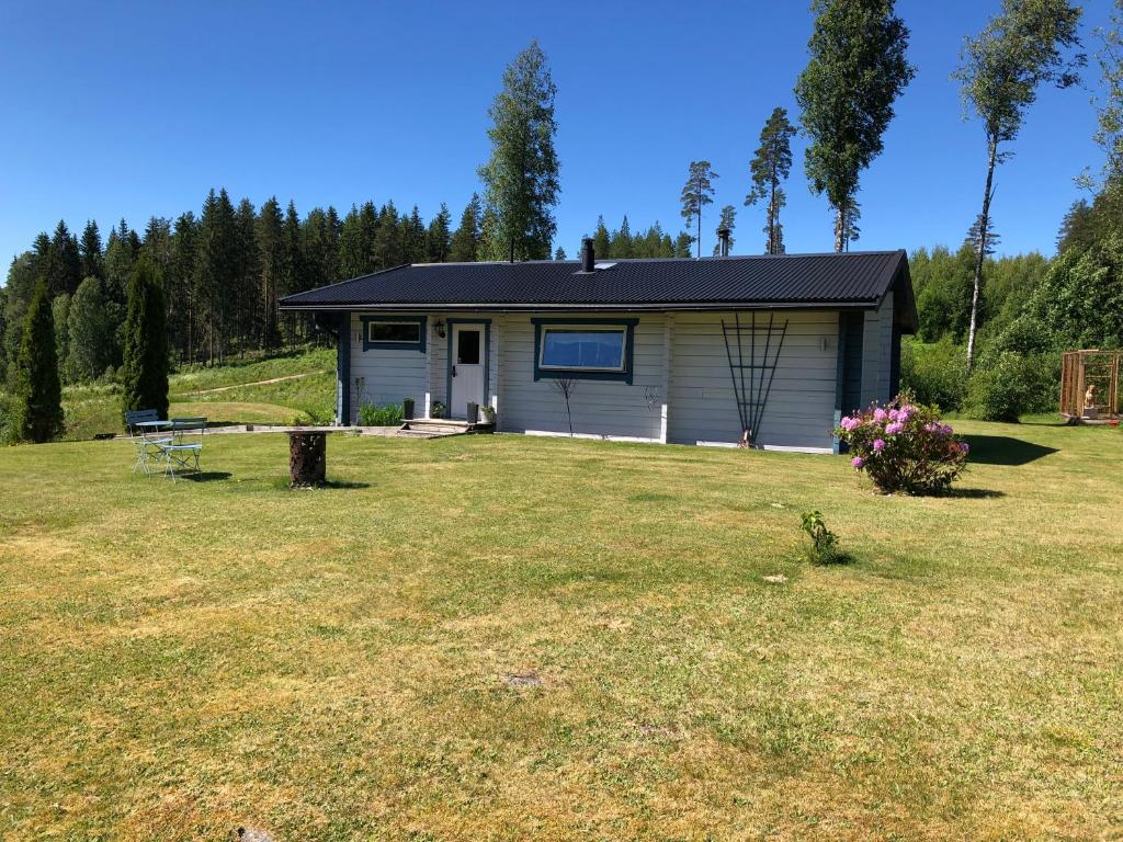 a small house in the middle of a yard at Mysig timmerstuga med braskamin nära Hovfjället in Torsby