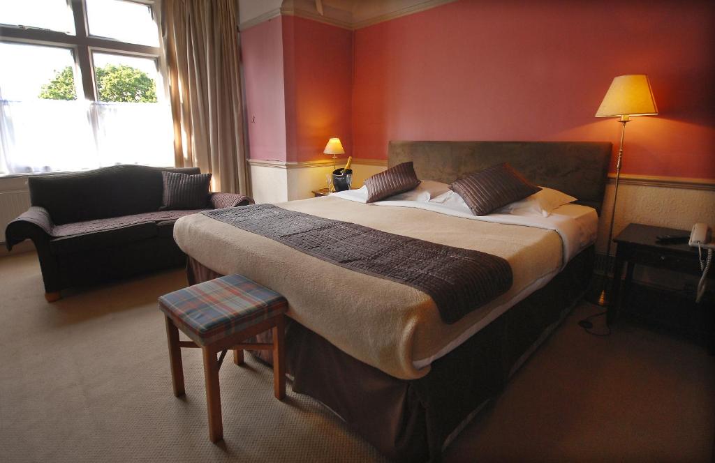 a bedroom with a large bed and a couch at Tree Hotel at Iffley in Oxford