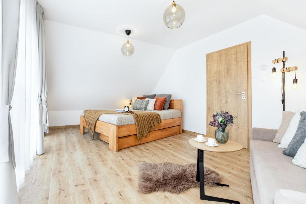 a white living room with a bed and a table at Apartmány Karlovy Dvory in Horní Planá