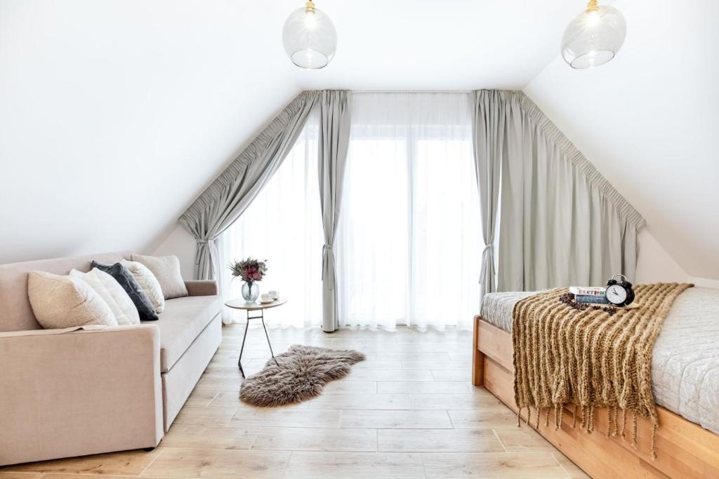 a bedroom with a bed and a couch at Apartmány Karlovy Dvory in Horní Planá