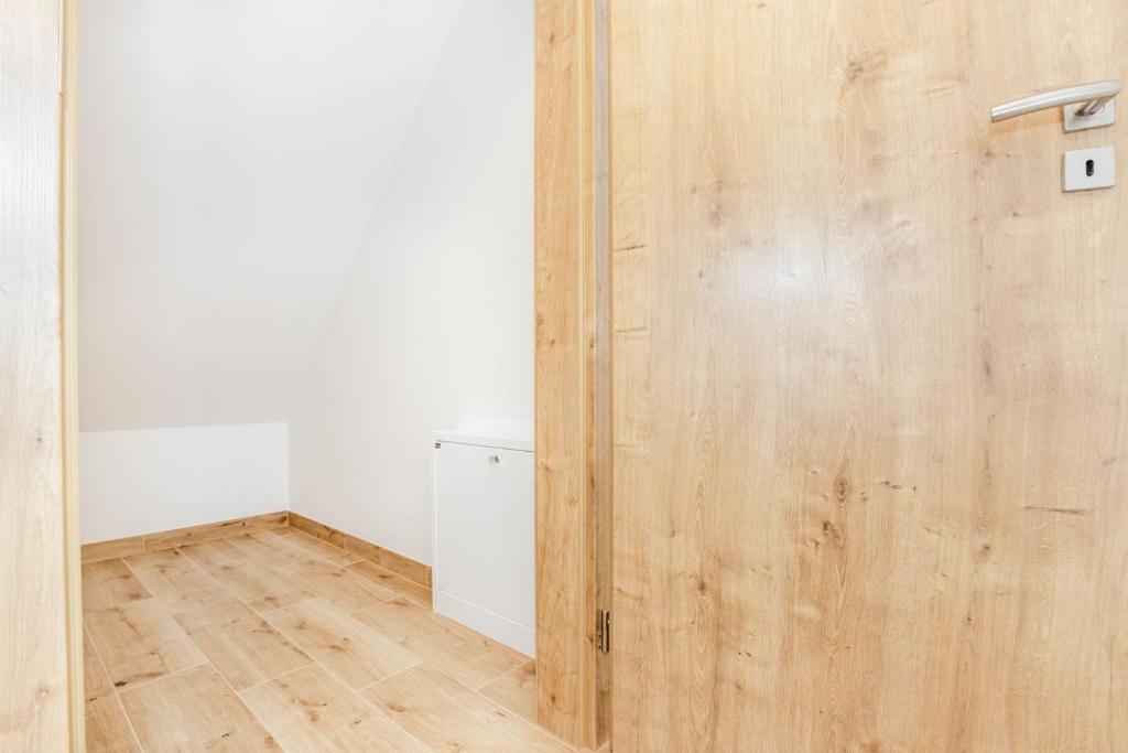 a wooden door in a room with a wooden floor at Apartmány Karlovy Dvory in Horní Planá