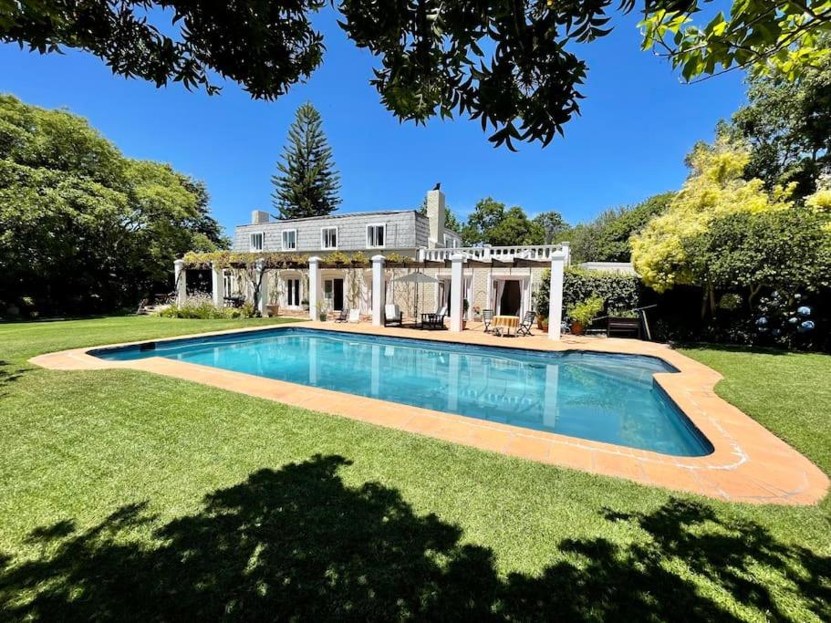 a house with a swimming pool in the yard at Charming Guest Suite in the Constantia Wine Valley in Cape Town