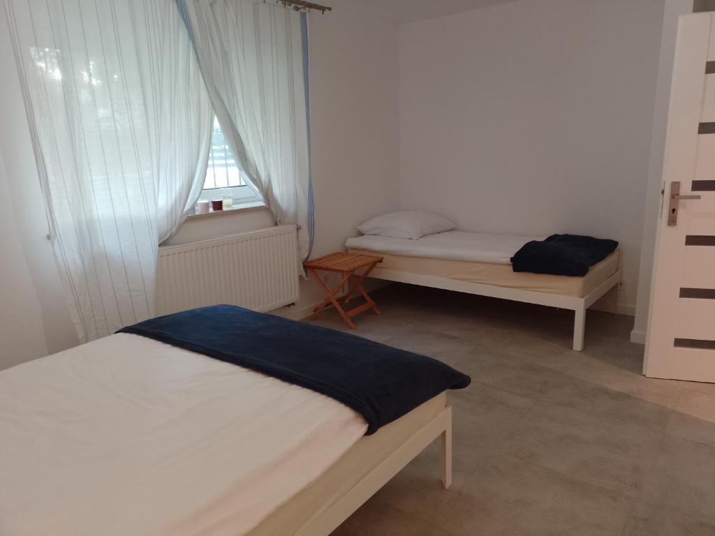 a bedroom with two beds and a window at Guest House Ustka in Ustka