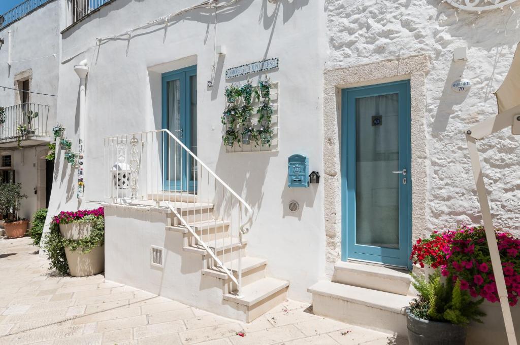 a white building with stairs and a blue door at Dimore del TEMPO PERS0 Prima Luce in Ostuni
