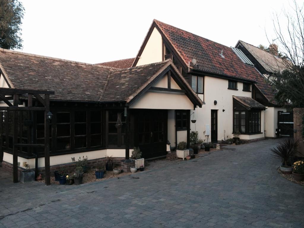 a large white building with a brick driveway at Kendall Lodge in Burwell