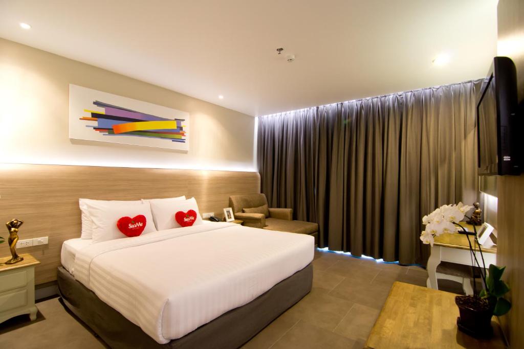 a hotel room with a bed and a television at Sea Me Spring Too Hotel in Pattaya Central