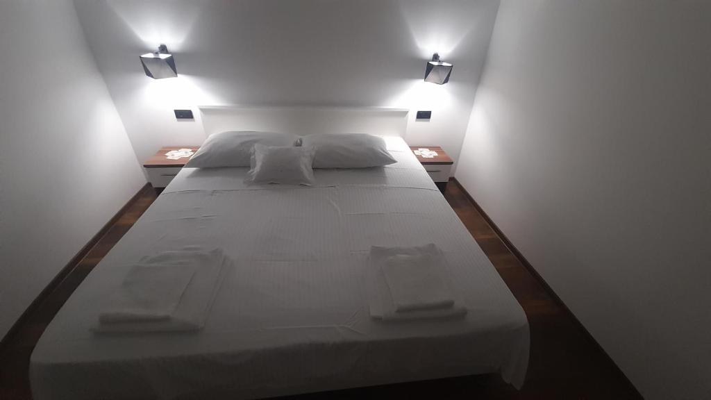 Kampor的住宿－Marija šimičić，一张大白色的床,房间有两个灯