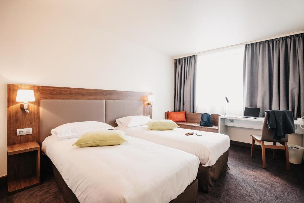 Pokój hotelowy z 2 łóżkami i biurkiem w obiekcie Campanile Metz Centre - Gare w Metz