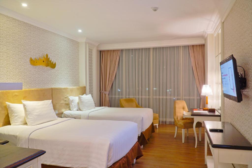 Postel nebo postele na pokoji v ubytování Swiss-Belhotel Lampung