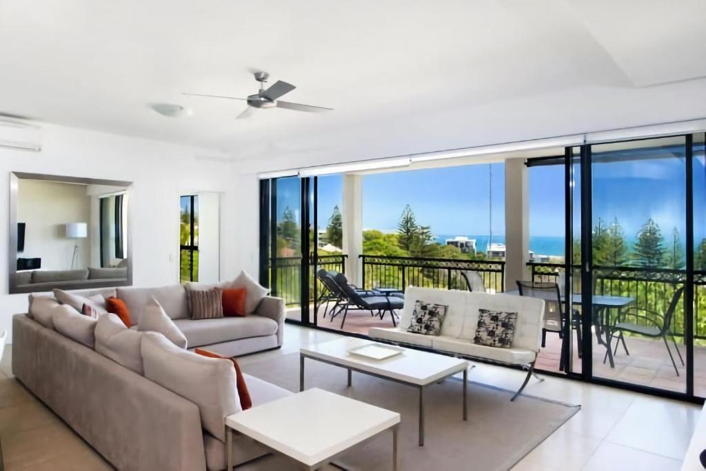 a living room with a couch and a table at 3 Hilltop Villas White Water Views from the Heart of Sunshine in Sunshine Beach