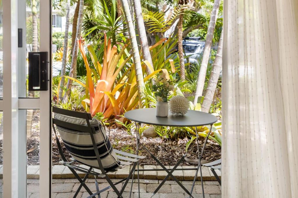 a table and two chairs and a table with a table and trees at 5 Samarin Court Convenient and Comfortable in Sunshine Beach