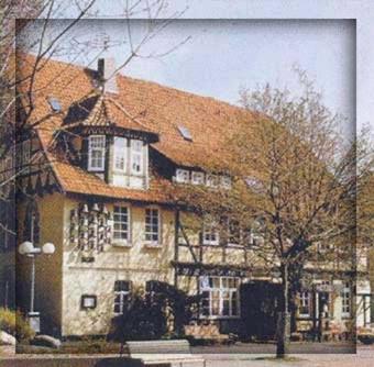 una gran casa de piedra con techo rojo en Hotel Ratskeller Gehrden, en Gehrden