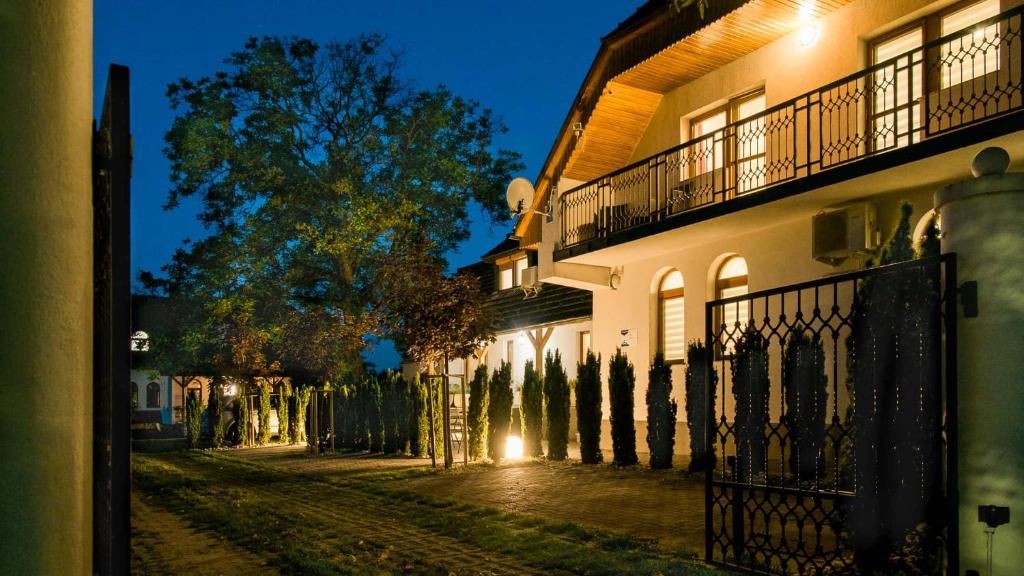 dom z płotem obok ulicy w nocy w obiekcie Diófa Apartman w mieście Keszthely