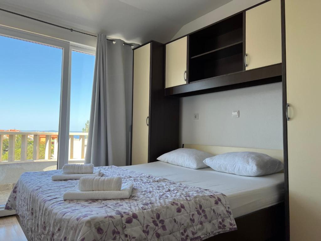 1 dormitorio con 1 cama con 2 almohadas en Villa Marina Promajna, en Promajna