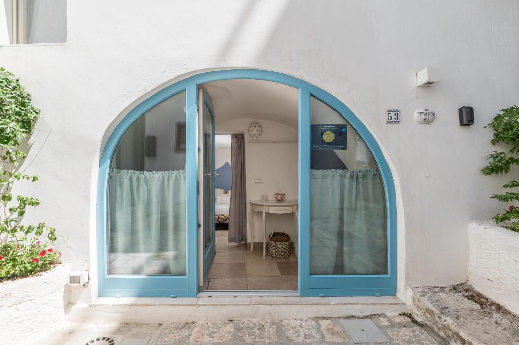 an archway with a blue door on a building at Dimore del TEMPO PERS0 Terrae Globus in Ostuni