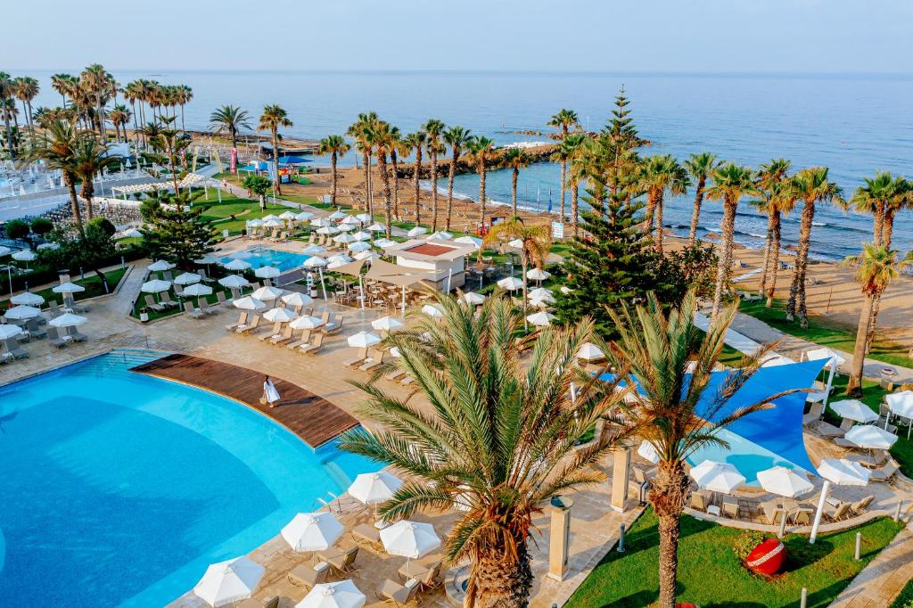 an aerial view of a resort with a pool and palm trees at Louis Ledra Beach in Paphos City
