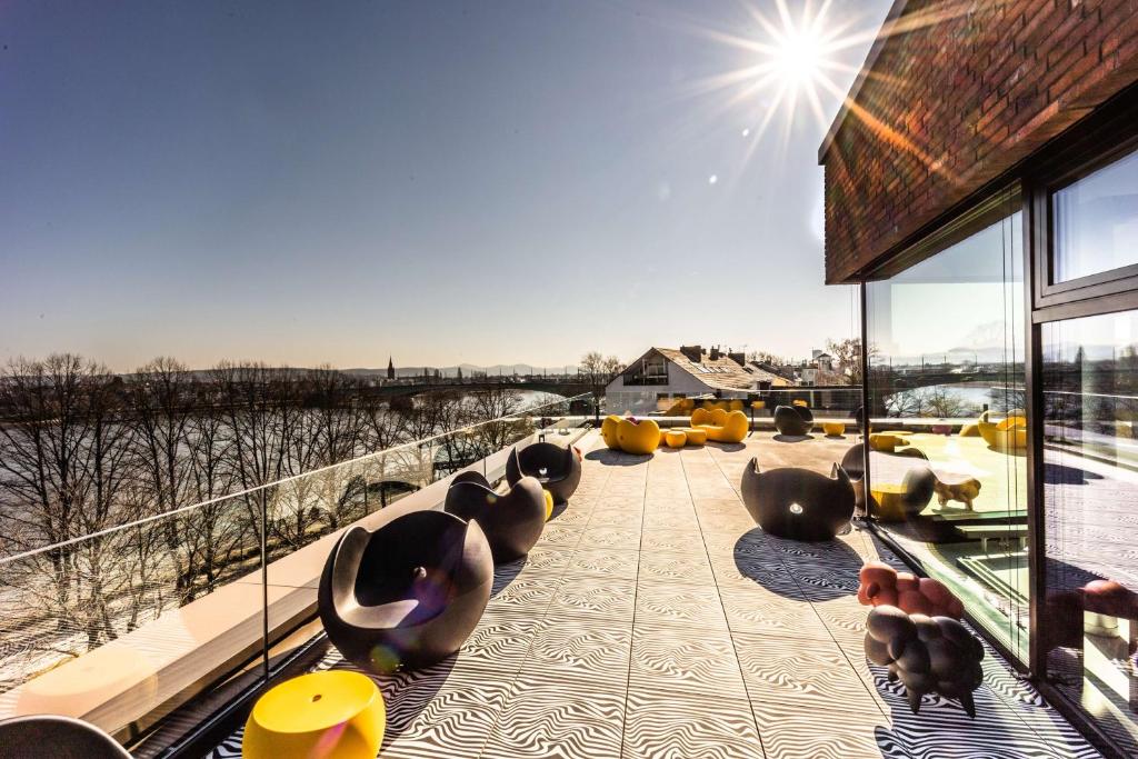 een balkon met stoelen en uitzicht op het water bij prizeotel Bonn-City in Bonn